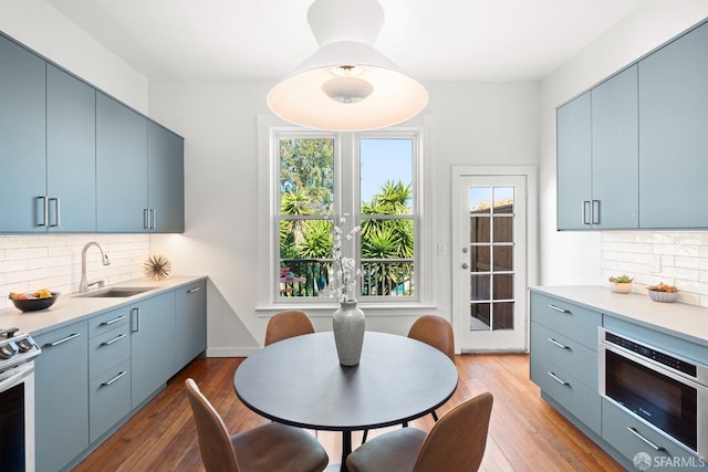 2553 Folsom St Unit A, San Francisco, CA 94110 - kitchen with blue cabinetry, a sink, appliances with stainless steel finishes, and tasteful backsplash