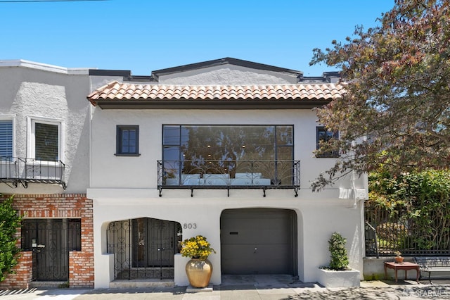 803 Vermont St, San Francisco, CA 94107 - mediterranean / spanish house featuring a balcony, stucco siding, a tile roof, a garage, and brick siding
