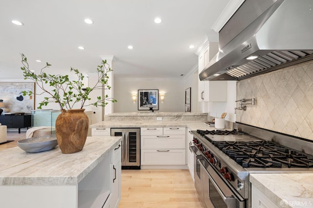 803 Vermont St, San Francisco, CA 94107 - kitchen featuring wine cooler, exhaust hood, stainless steel range with gas cooktop, white cabinetry, and backsplash