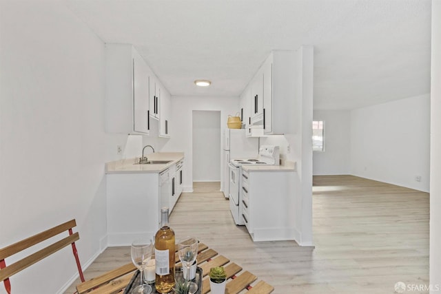 kitchen with electric stove, light countertops, light wood finished floors, and white cabinetry