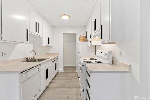 kitchen with light countertops, white appliances, a sink, and white cabinets