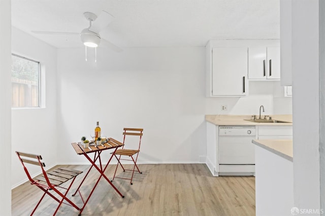 kitchen featuring a sink, white cabinets, light countertops, light wood-type flooring, and dishwasher