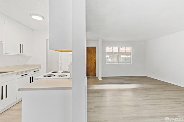 kitchen featuring light countertops, light wood-style floors, white cabinetry, a sink, and range with electric cooktop