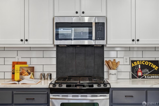 kitchen with appliances with stainless steel finishes, white cabinets, and decorative backsplash