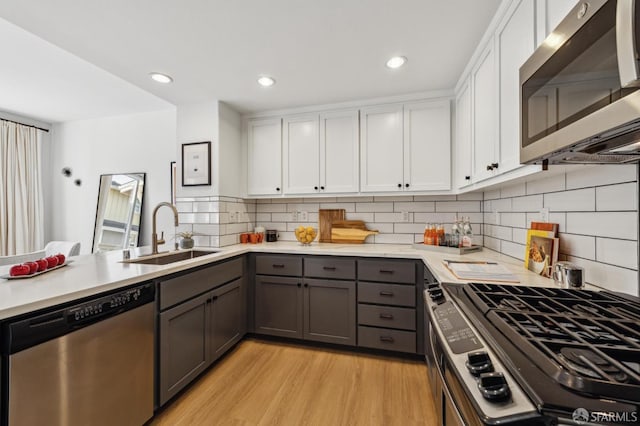 kitchen featuring white cabinets, appliances with stainless steel finishes, sink, and gray cabinets