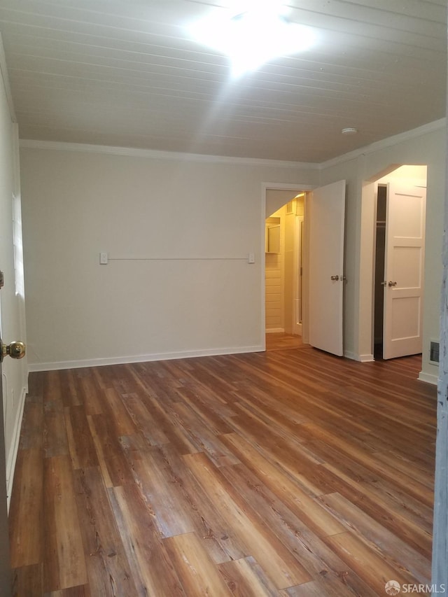 empty room featuring crown molding and hardwood / wood-style floors