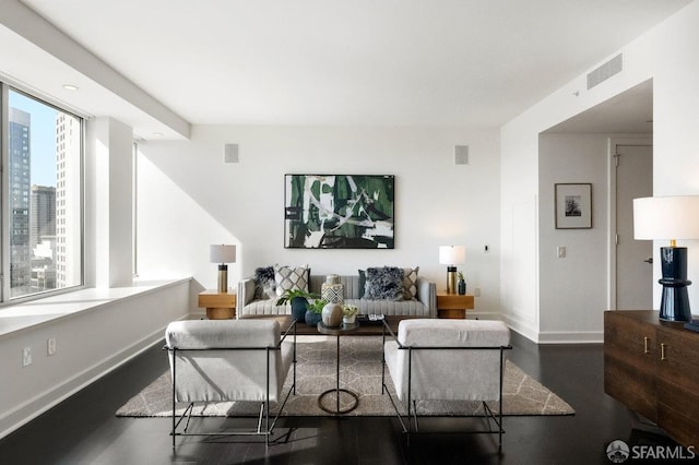 living area with baseboards, visible vents, dark wood finished floors, and a city view