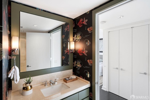 bathroom featuring vanity and wallpapered walls