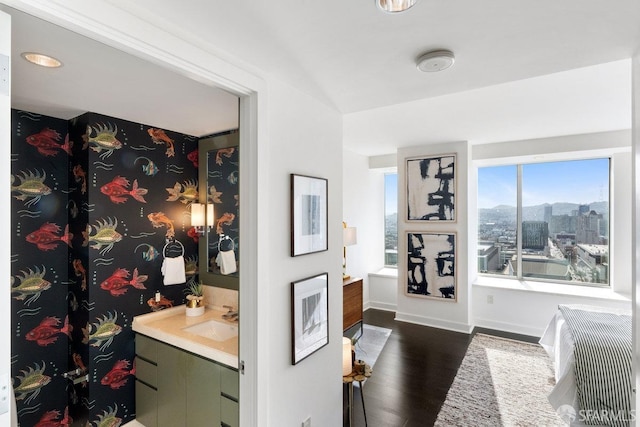 interior space with a view of city, baseboards, dark wood finished floors, and a sink