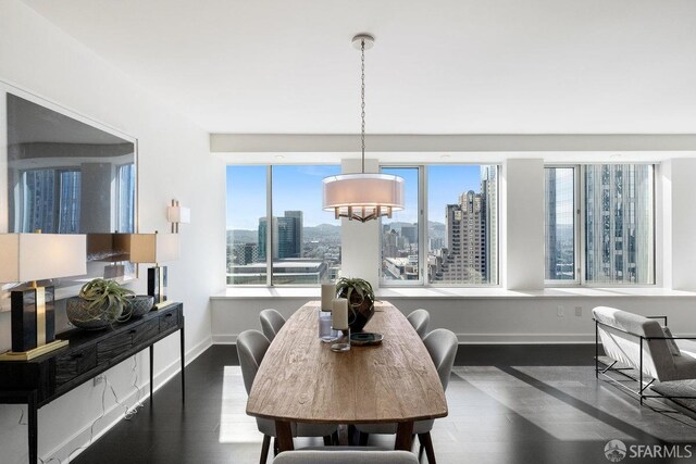 dining room with a view of city, dark wood-style flooring, and baseboards