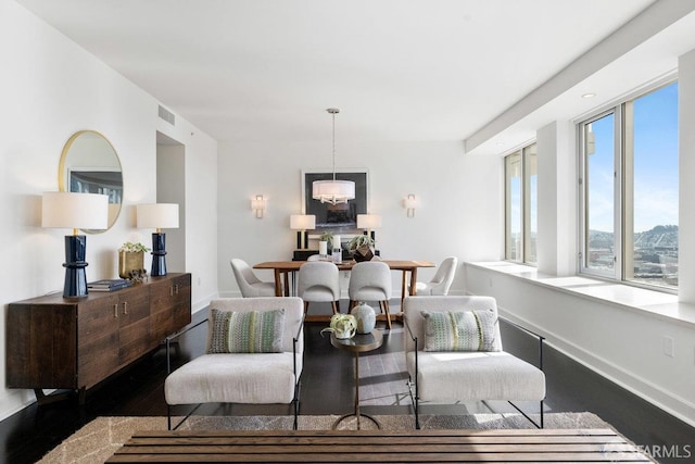 living room with wood finished floors, visible vents, and baseboards