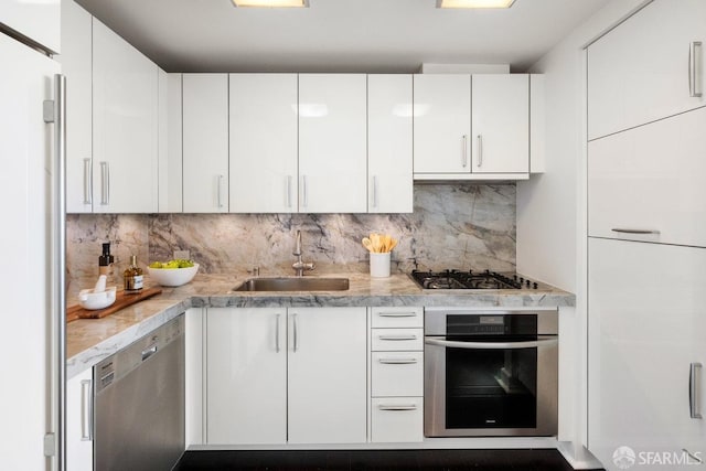 kitchen featuring white cabinets, stainless steel appliances, and a sink