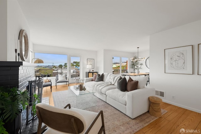245 Skyline Dr, Daly City, CA 94015 - living room with wood finished floors, a brick fireplace, and a chandelier