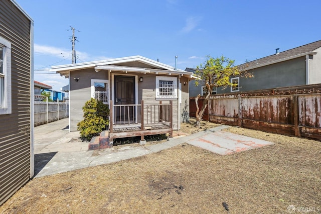 rear view of house with a fenced backyard and a patio