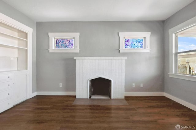 unfurnished living room featuring baseboards, built in features, wood finished floors, and a tile fireplace