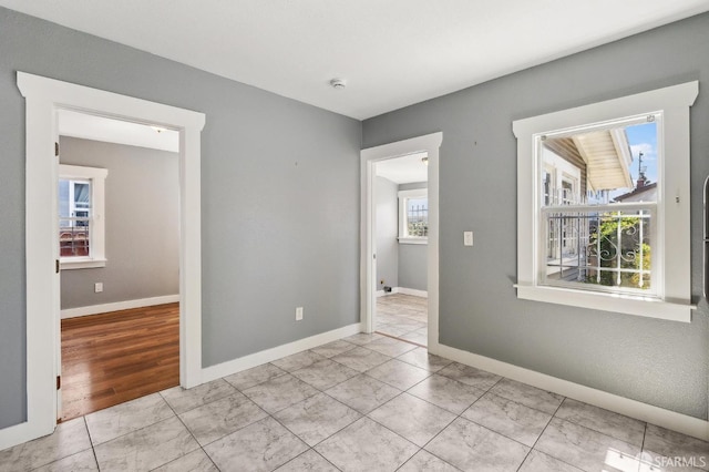 empty room featuring light tile patterned flooring and baseboards