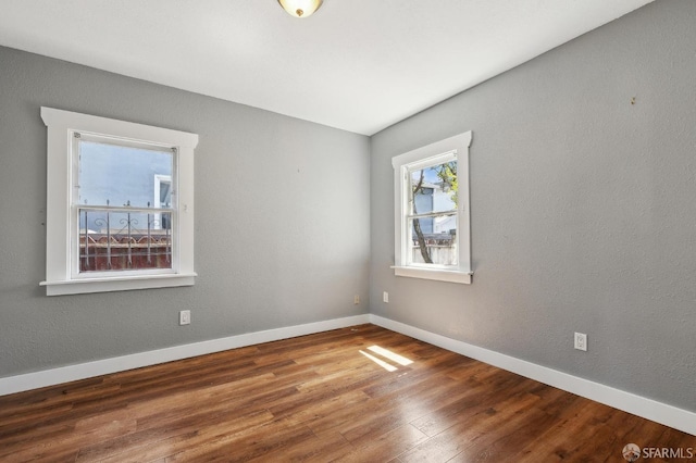 empty room with baseboards and wood finished floors