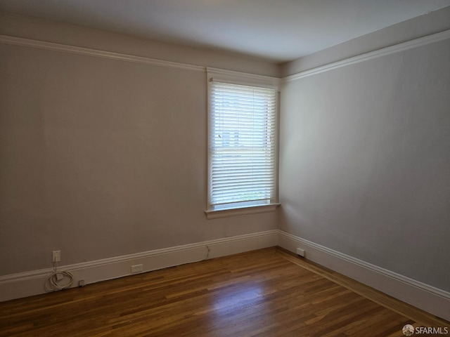 unfurnished room with crown molding and dark hardwood / wood-style flooring