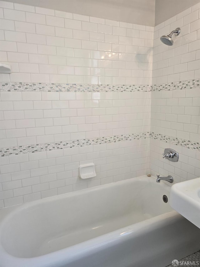 bathroom featuring tiled shower / bath