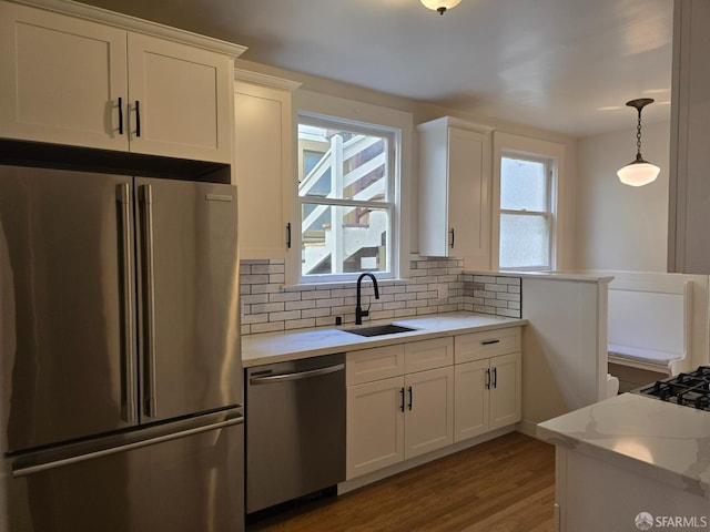 kitchen featuring appliances with stainless steel finishes, white cabinets, sink, and plenty of natural light