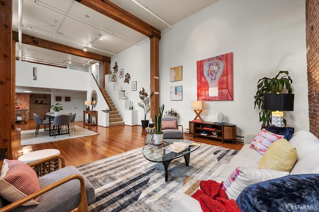 461 2nd St Unit C135, San Francisco, CA 94107 - living area featuring stairs, wood finished floors, rail lighting, brick wall, and baseboard heating