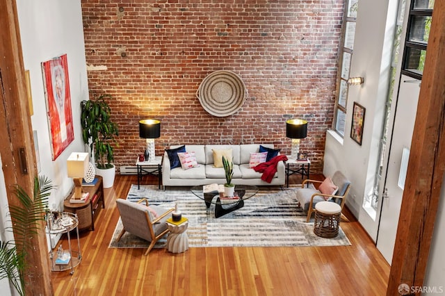 461 2nd St Unit C135, San Francisco, CA 94107 - living area with brick wall, wood finished floors, a baseboard radiator, and healthy amount of natural light
