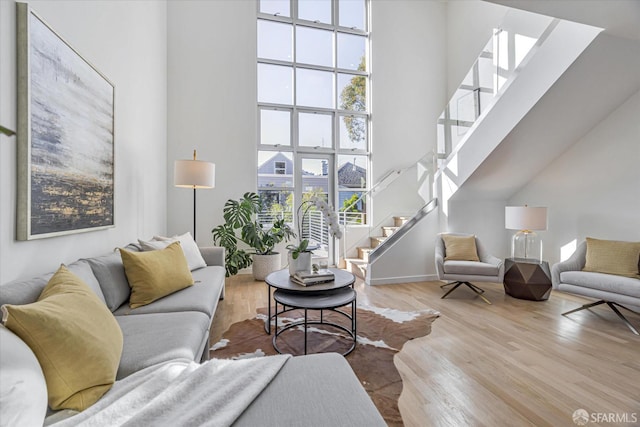 living room with light hardwood / wood-style flooring and a high ceiling