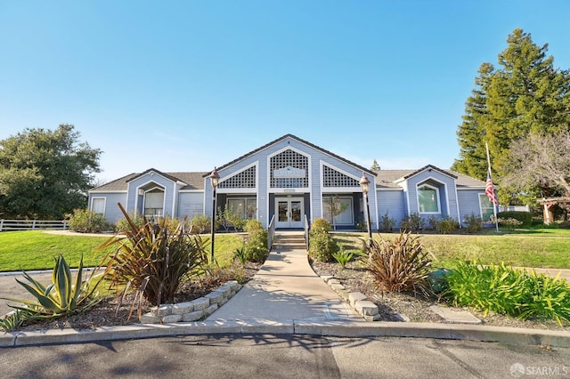 view of front of house featuring french doors and a front lawn