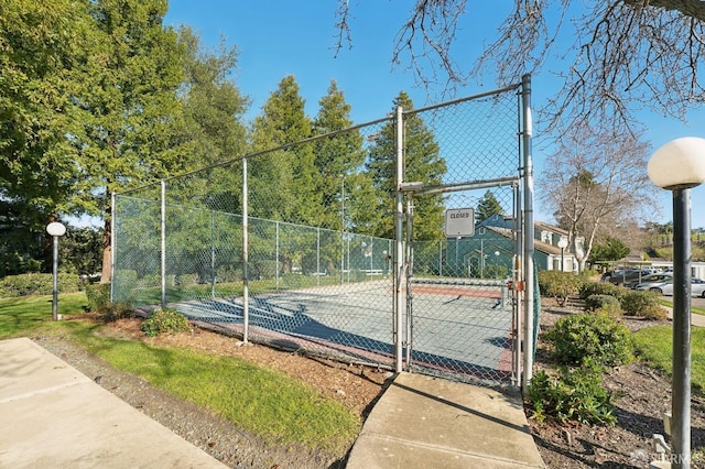 view of tennis court with basketball hoop