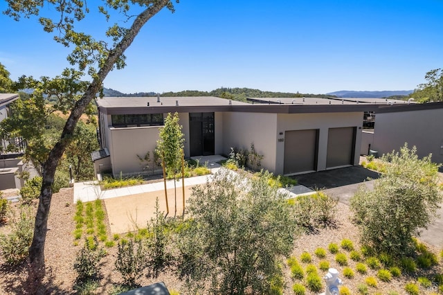 view of front of home with a garage, aphalt driveway, and stucco siding