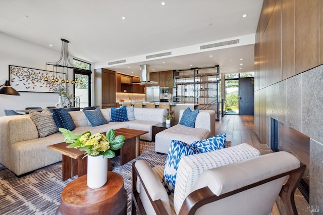 living room featuring a fireplace, visible vents, and an inviting chandelier