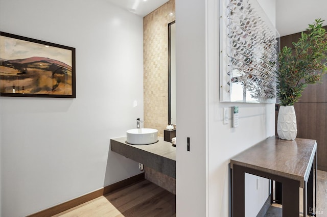 bathroom featuring baseboards, vanity, and wood finished floors