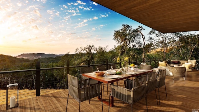 deck featuring outdoor dining area, outdoor lounge area, and a mountain view