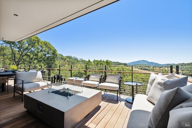wooden deck with a mountain view and an outdoor living space with a fire pit