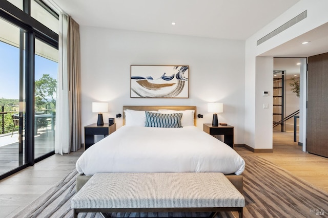 bedroom with access to outside, light wood finished floors, expansive windows, and recessed lighting