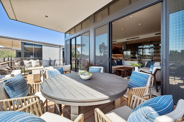 balcony featuring an outdoor living space, visible vents, and a sunroom