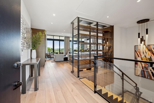 hall with light wood-type flooring, floor to ceiling windows, and recessed lighting