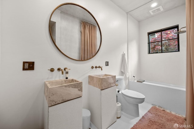 bathroom with vanity, toilet, and visible vents