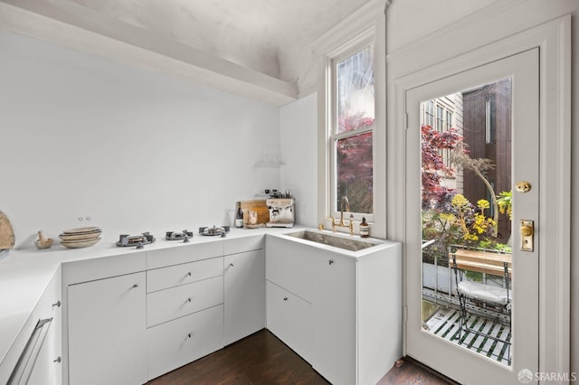 kitchen with light countertops, white cabinets, dark wood finished floors, and white gas stovetop