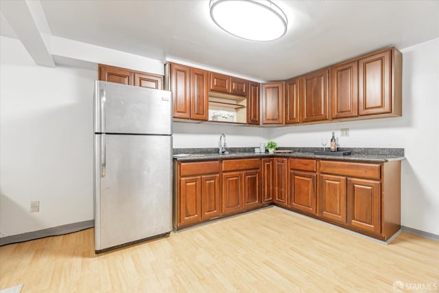 kitchen featuring sink, stainless steel refrigerator, and light hardwood / wood-style floors