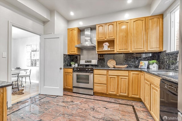 kitchen featuring dishwasher, decorative backsplash, stainless steel range with gas cooktop, dark stone counters, and wall chimney exhaust hood