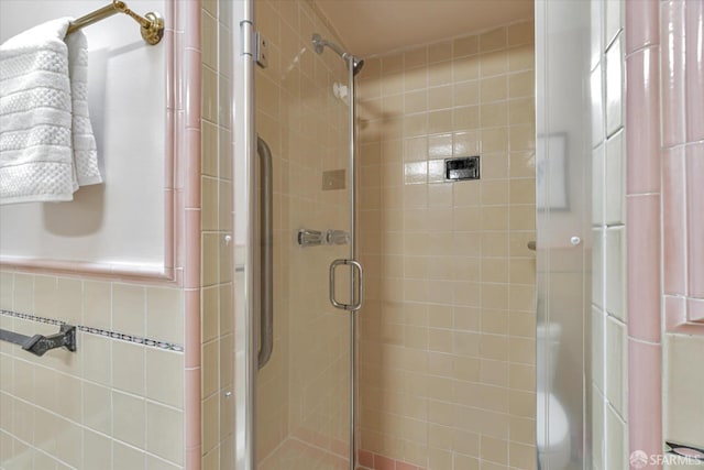 bathroom with tile walls and a shower with shower door