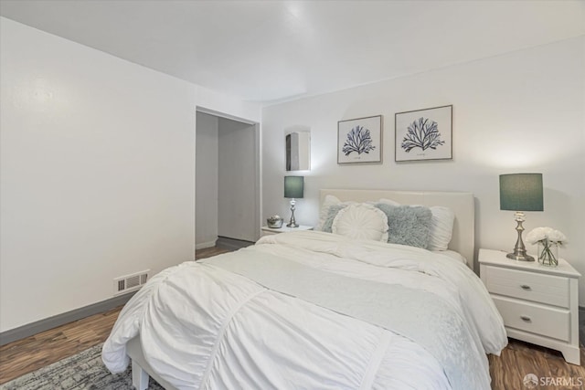 bedroom with dark hardwood / wood-style floors