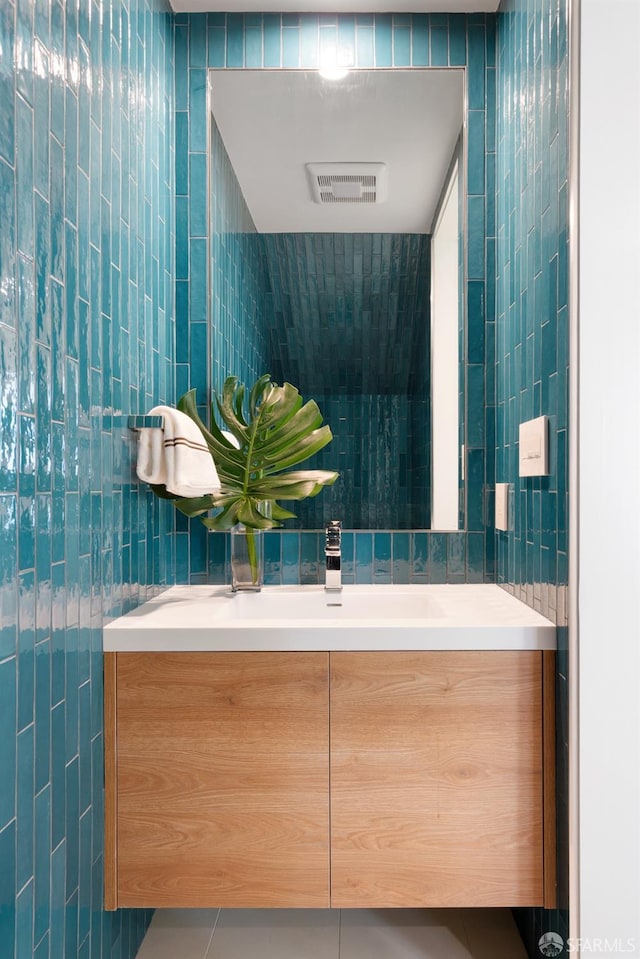 bathroom with tile patterned flooring, vanity, and tile walls