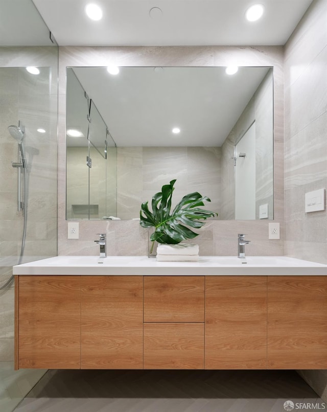 bathroom featuring vanity, a tile shower, and backsplash