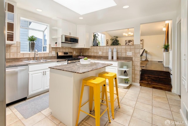 636 Edgemar Ave, Pacifica, CA 94044 - kitchen with stainless steel appliances, open shelves, decorative backsplash, white cabinetry, and recessed lighting