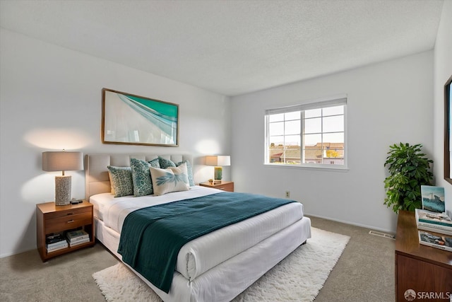 bedroom featuring light colored carpet and a textured ceiling