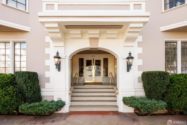 property entrance with stucco siding and french doors