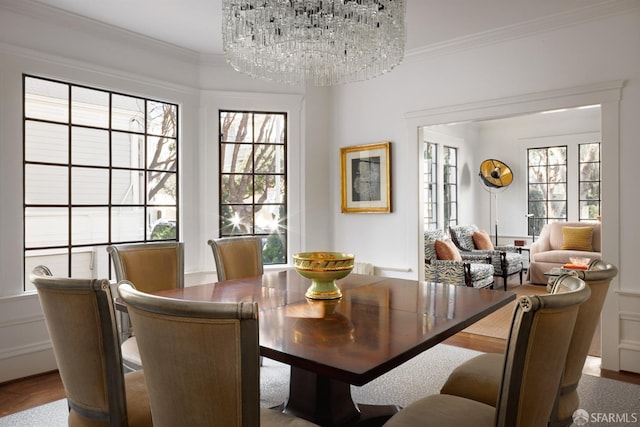 dining room featuring a notable chandelier, crown molding, and wood finished floors