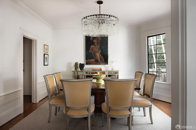 dining area featuring a notable chandelier, crown molding, and wood finished floors